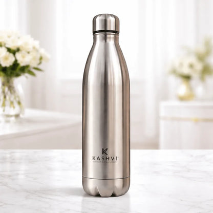 Stainless steel water bottle with 'Kashvi' branding on a white surface with a blurred background