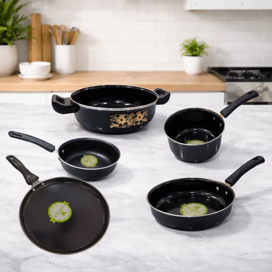 Set of black cookware with handles on a kitchen counter.