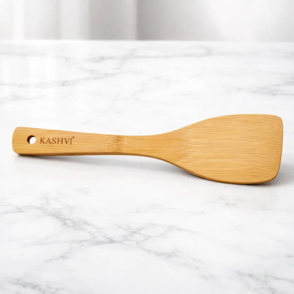 Wooden spatula with 'Kashvi' branding on a marble surface